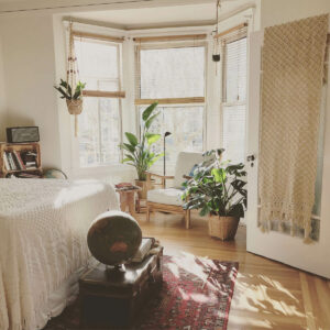 Hyggeligt soveværelse med lænestol og solstråler