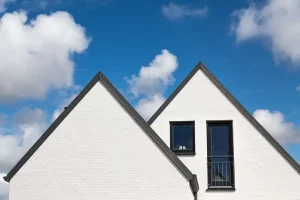 Udsigt over et hvidt hus med sorte tagsten.